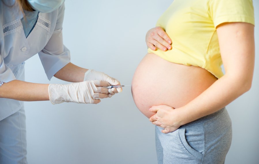 Einer Schwangeren wird mit einer Spritze Fruchtwasser aus dem Bauch entnommen.