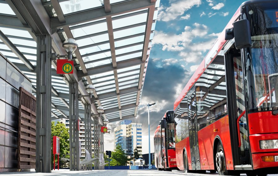 ÖPNV - Zwei rote Stadtbusse halten an einer modernen Bushaltestelle.