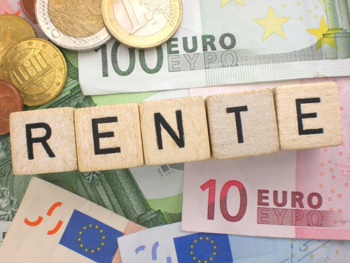 Verschiedene Euro-Scheine und Münzen liegen dicht beieinander. Darüber ist mit Holzbuchstaben das Wort „Rente“ geschrieben.