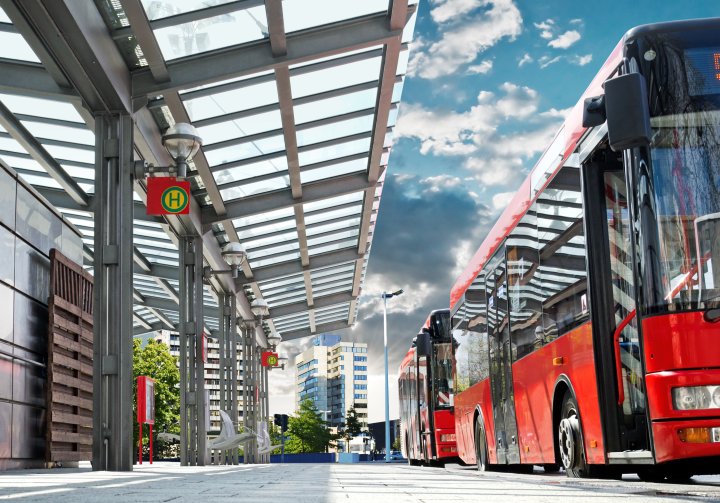 ÖPNV - Zwei rote Stadtbusse halten an einer modernen Bushaltestelle.