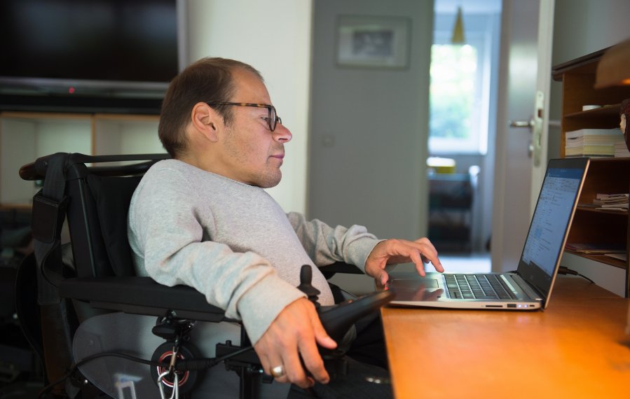 Ein Mann sitzt vor einen Laptop und prüft seine E-Mails.