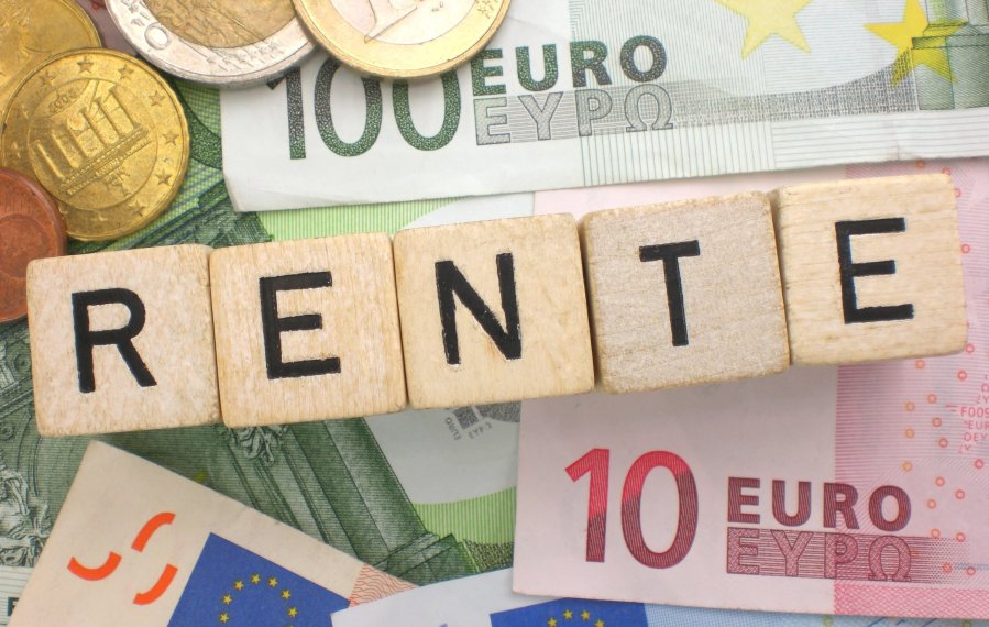 Verschiedene Euro-Scheine und Münzen liegen dicht beieinander. Darüber steht auf Holzwürfeln das Wort „Rente“ geschrieben.